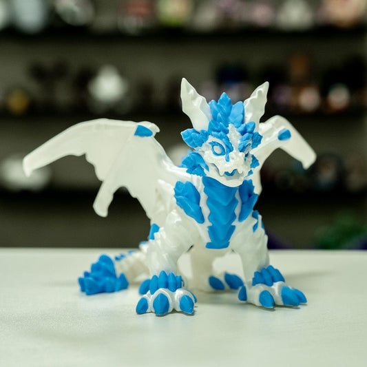 Dragón Frosty descansando, figura 3D en colores blanco y azul